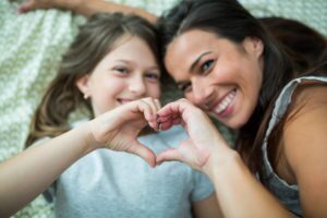 Mom and daughter display hand heart Call For Kindness
